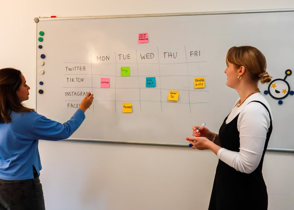 Team planning social media strategy on whiteboard